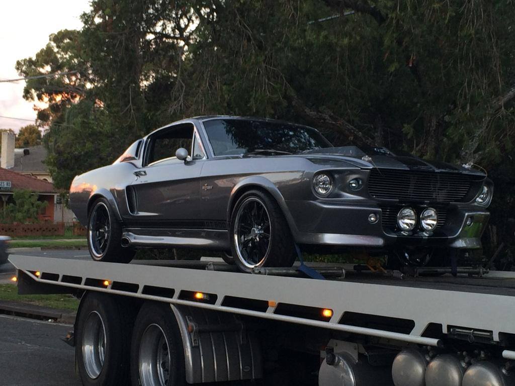 A silver Shelby Mustang loaded on the flatbed